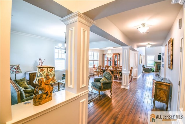 corridor featuring ornamental molding, visible vents, dark wood-style flooring, and ornate columns