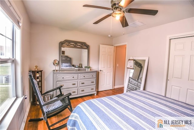 bedroom featuring wood finished floors, a ceiling fan, and baseboards