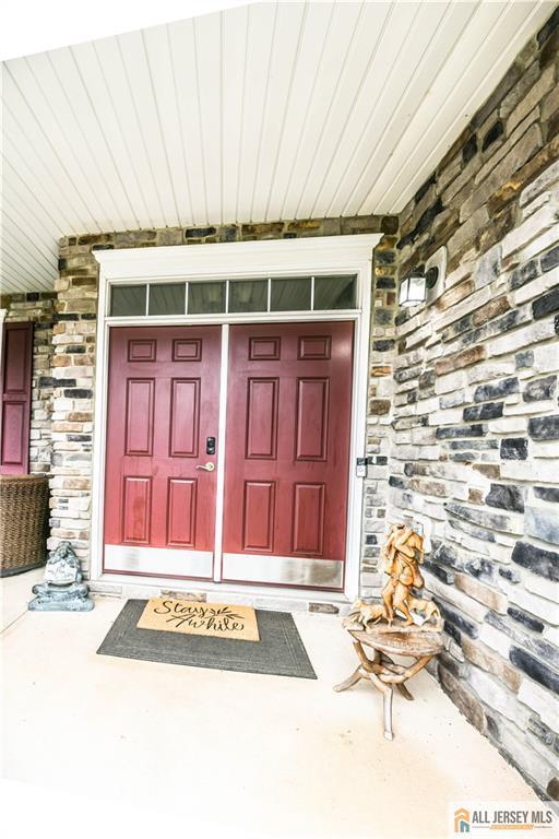 entrance to property featuring stone siding and covered porch