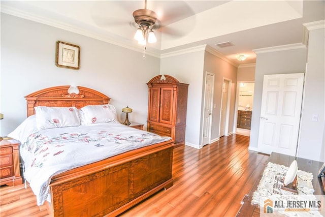 bedroom featuring visible vents, baseboards, a ceiling fan, wood finished floors, and ornamental molding