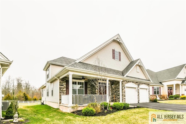 view of front facade with aphalt driveway, fence, a porch, a front yard, and a garage