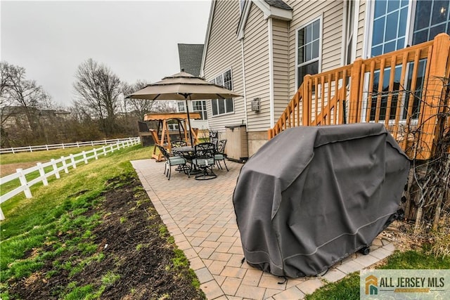 view of patio with grilling area, stairway, fence, and outdoor dining area