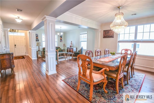 dining room with decorative columns, visible vents, and an inviting chandelier