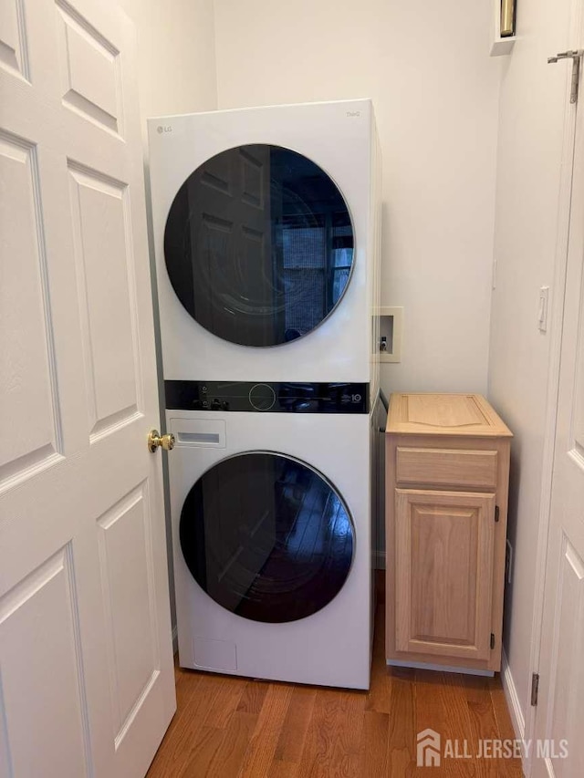 117 Providence Blvd, South Brunswick, NJ 08824 - washroom featuring stacked washer / dryer, cabinet space, and light wood finished floors