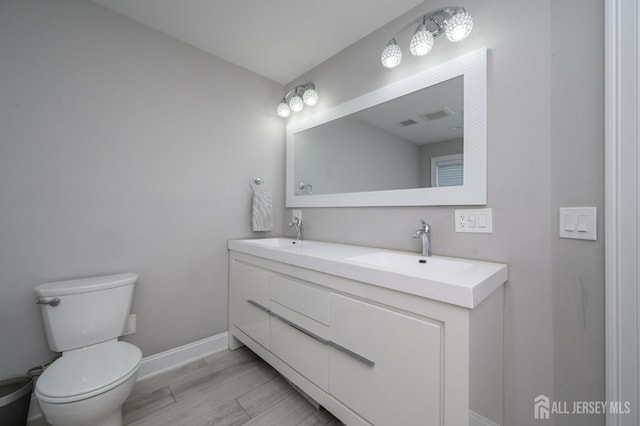 328 Coolidge Dr, Kenilworth, NJ 07033 - bathroom with double vanity, toilet, baseboards, and wood finished floors