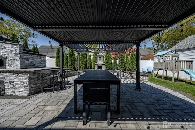 328 Coolidge Dr, Kenilworth, NJ 07033 - view of patio featuring an outdoor stone fireplace, a playground, a pergola, and outdoor dining space
