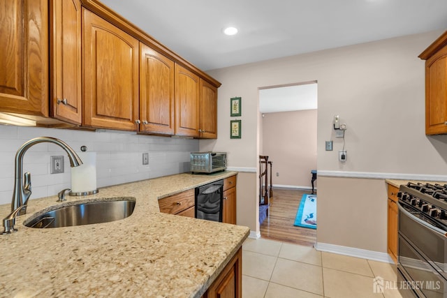 11 Diana Ct, East Brunswick, NJ 08816 - kitchen with range with two ovens, a sink, brown cabinetry, light stone countertops, and backsplash