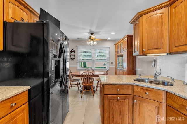 11 Diana Ct, East Brunswick, NJ 08816 - kitchen with black fridge with ice dispenser, a sink, brown cabinets, ceiling fan, and light tile patterned flooring