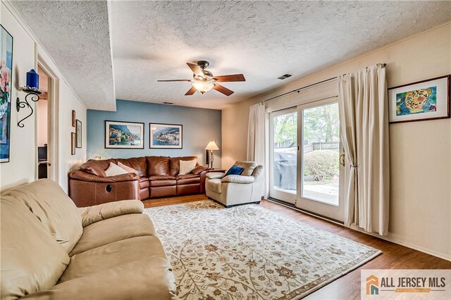 13 Harper Rd, South Brunswick, NJ 08852 - living room with wood finished floors, a ceiling fan, a textured ceiling, and baseboards
