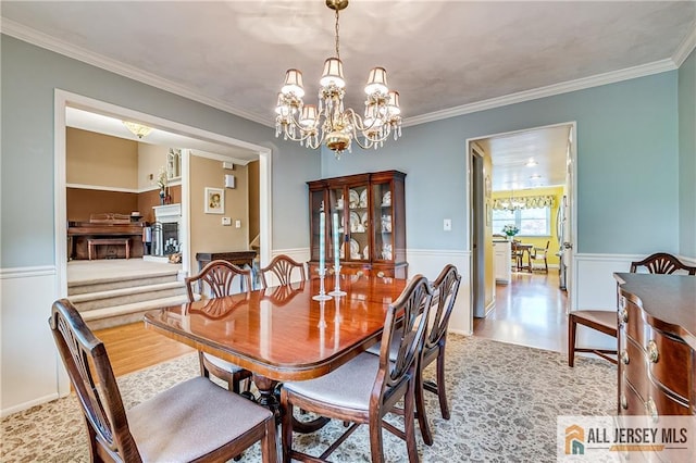 13 Harper Rd, South Brunswick, NJ 08852 - dining room with a chandelier, wainscoting, crown molding, wood finished floors, and a fireplace