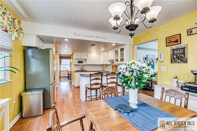 13 Harper Rd, South Brunswick, NJ 08852 - dining room with light wood-style floors, a chandelier, and baseboards