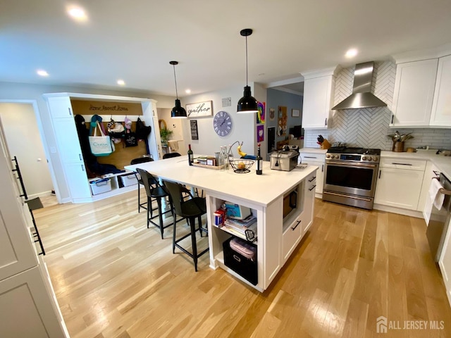 22 E Zoller Rd, East Brunswick, NJ 08816 - kitchen with wall chimney exhaust hood, stainless steel appliances, a kitchen bar, white cabinetry, and recessed lighting