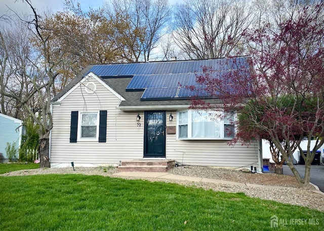 22 E Zoller Rd, East Brunswick, NJ 08816 - view of front facade with solar panels, a front lawn, and roof with shingles