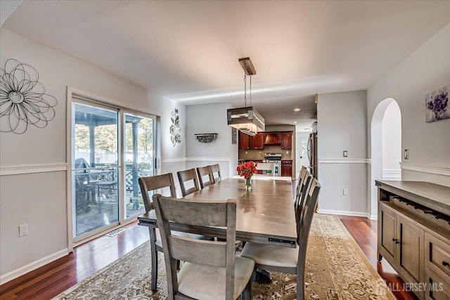 74 Gates Rd, Franklin, NJ 08873 - dining area featuring dark wood-style flooring, arched walkways, baseboards, and visible vents