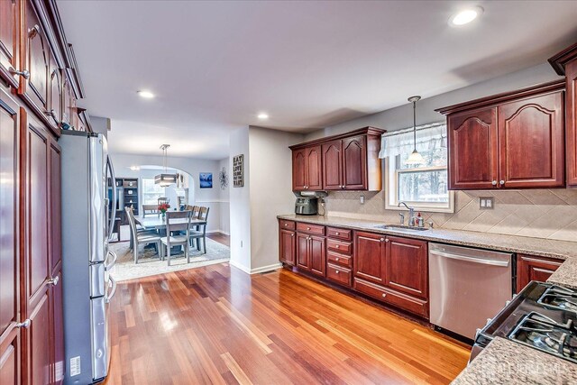 74 Gates Rd, Franklin, NJ 08873 - kitchen with backsplash, appliances with stainless steel finishes, a sink, and light wood-type flooring