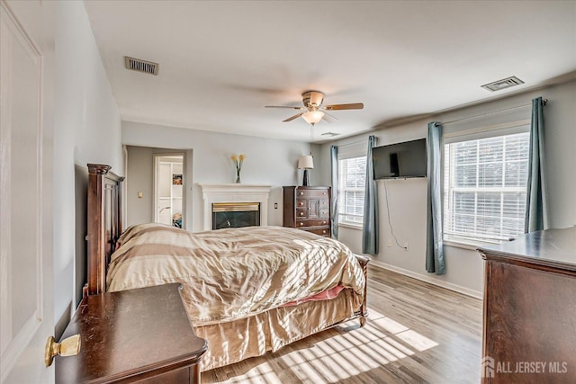 74 Gates Rd, Franklin, NJ 08873 - bedroom with visible vents, light wood-style flooring, a glass covered fireplace, and baseboards