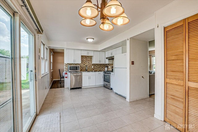 40 Azalea Dr, Edison, NJ 08820 - kitchen with appliances with stainless steel finishes, a chandelier, light tile patterned floors, backsplash, and under cabinet range hood