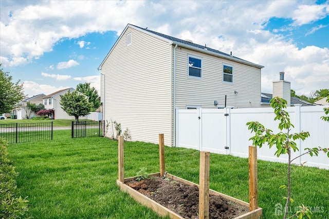 40 Azalea Dr, Edison, NJ 08820 - view of property exterior featuring a vegetable garden, a gate, and a chimney