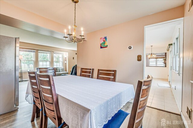 dining area featuring a chandelier, healthy amount of natural light, and wood finished floors
