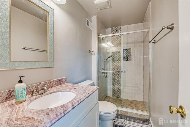 full bathroom featuring toilet, a shower stall, and vanity
