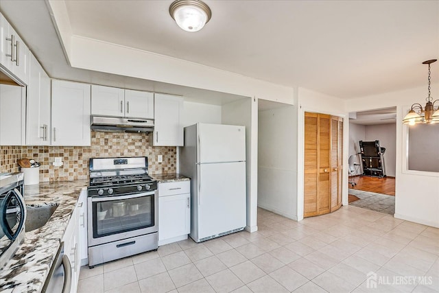 kitchen featuring appliances with stainless steel finishes, under cabinet range hood, tasteful backsplash, light stone counters, and white cabinets