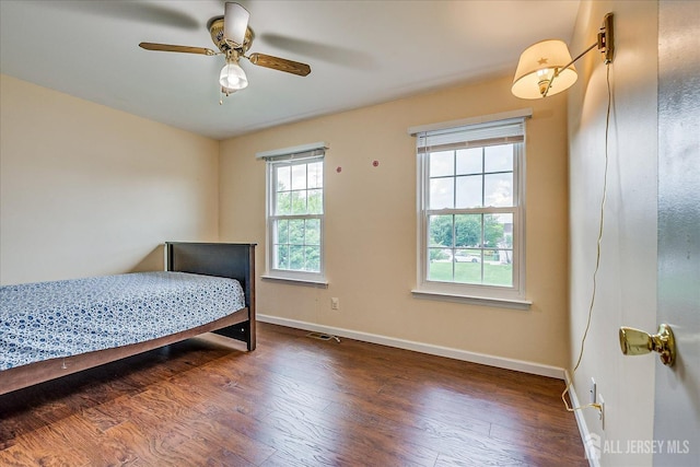 bedroom with baseboards, wood finished floors, and a ceiling fan