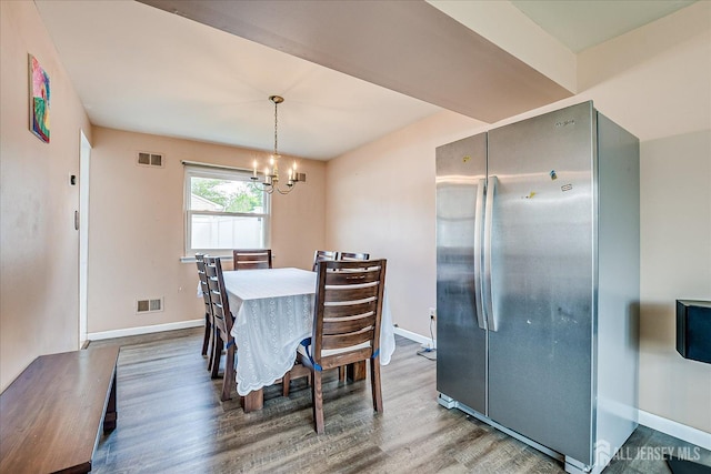 dining room featuring wood finished floors, baseboards, and a chandelier