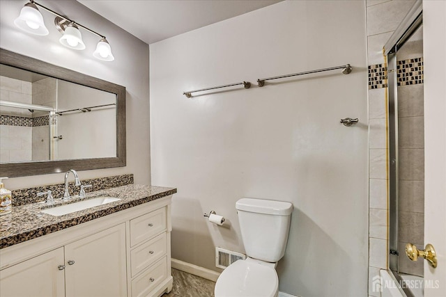 full bath with baseboards, tiled shower, toilet, and vanity