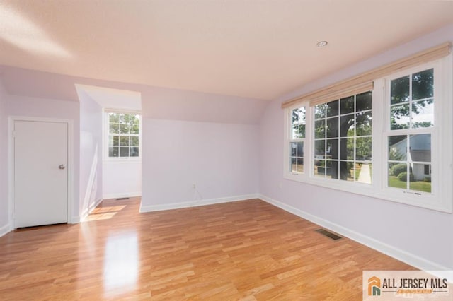 spare room with baseboards, visible vents, and light wood-style floors