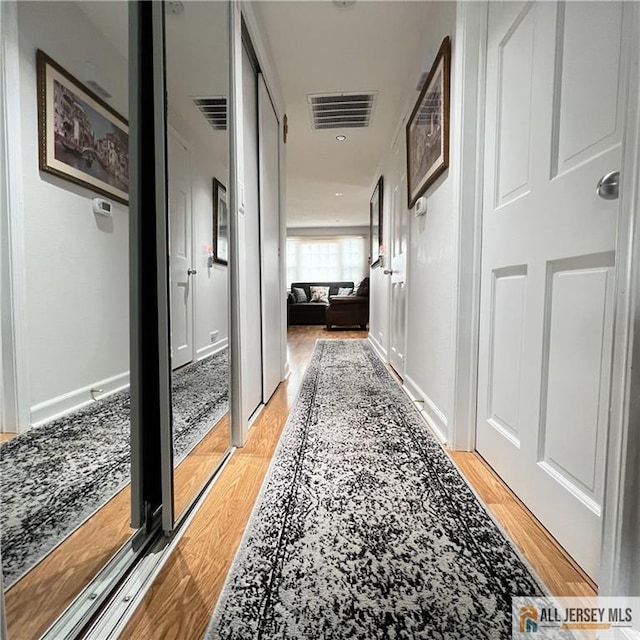 hall with visible vents and light wood finished floors