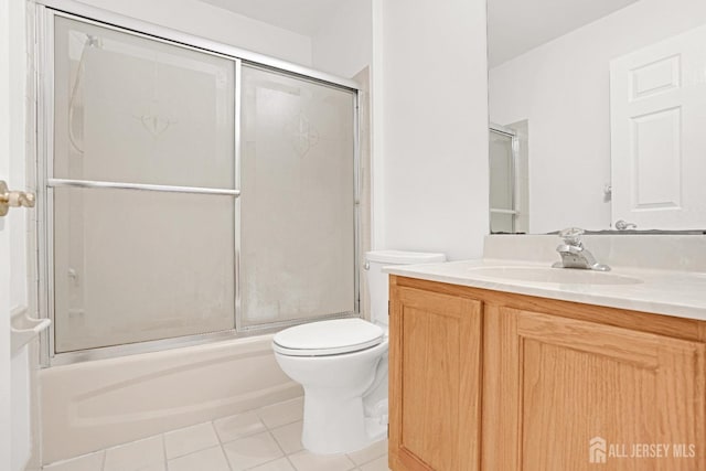 bathroom featuring tile patterned flooring, shower / bath combination with glass door, vanity, and toilet