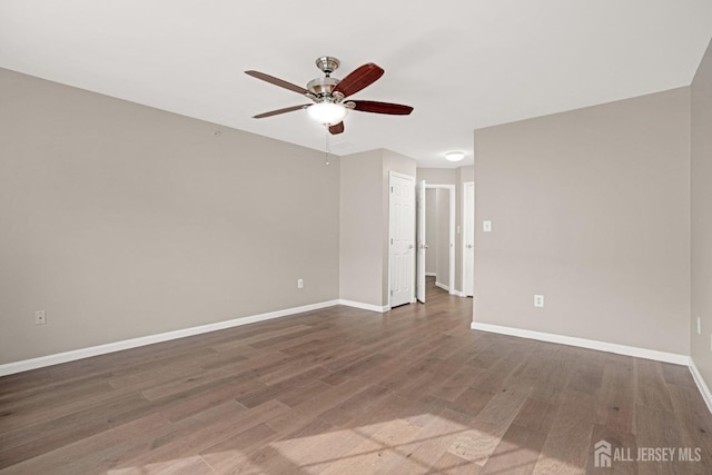 empty room with a ceiling fan, baseboards, and wood finished floors