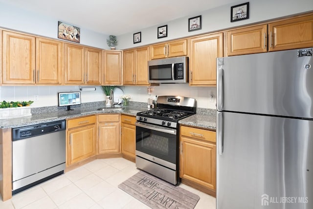 938 Thomas Ave, North Brunswick, NJ 08902 - kitchen featuring stainless steel appliances, a sink, stone countertops, light tile patterned floors, and light brown cabinets