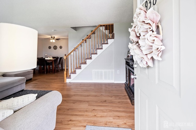 938 Thomas Ave, North Brunswick, NJ 08902 - entryway with a ceiling fan, light wood-type flooring, stairway, a fireplace, and baseboards