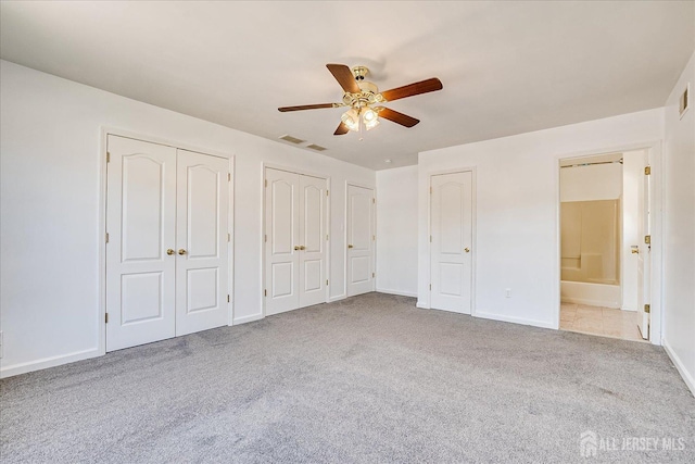 230 S 10th Ave S, Highland Park, NJ 08904 - unfurnished bedroom featuring two closets, carpet, baseboards, ceiling fan, and ensuite bathroom