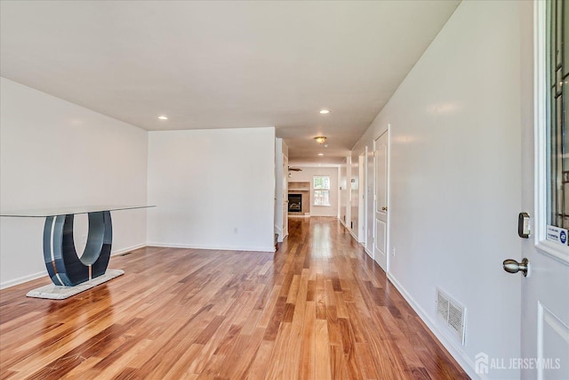 230 S 10th Ave S, Highland Park, NJ 08904 - unfurnished living room featuring a fireplace with raised hearth, light wood-style floors, recessed lighting, and baseboards