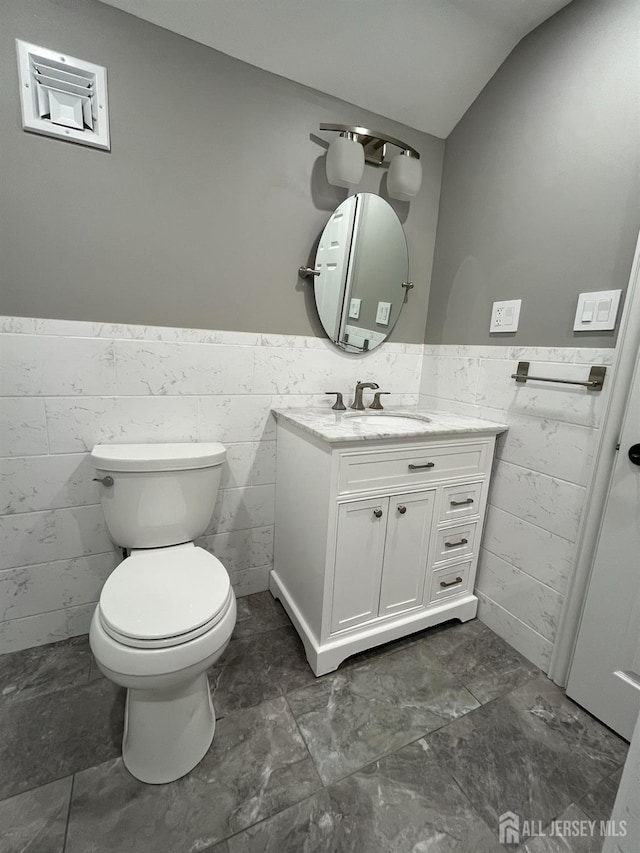 860 Barry Ave, Perth Amboy, NJ 08861 - half bath with a wainscoted wall, vanity, tile walls, and vaulted ceiling