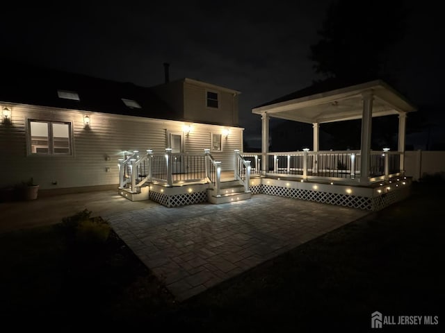 860 Barry Ave, Perth Amboy, NJ 08861 - patio at night featuring a patio, a wooden deck, and a gazebo