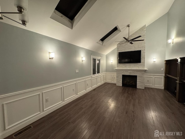 860 Barry Ave, Perth Amboy, NJ 08861 - unfurnished living room featuring a decorative wall, a stone fireplace, a ceiling fan, a wainscoted wall, and dark wood-type flooring
