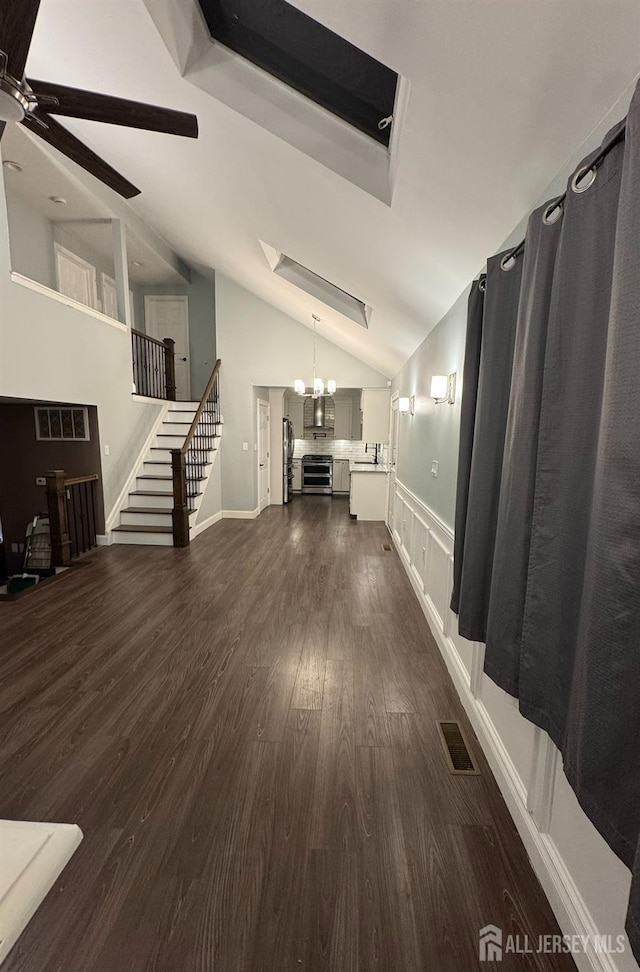 860 Barry Ave, Perth Amboy, NJ 08861 - unfurnished living room with a ceiling fan, stairs, dark wood-style floors, vaulted ceiling, and a wainscoted wall