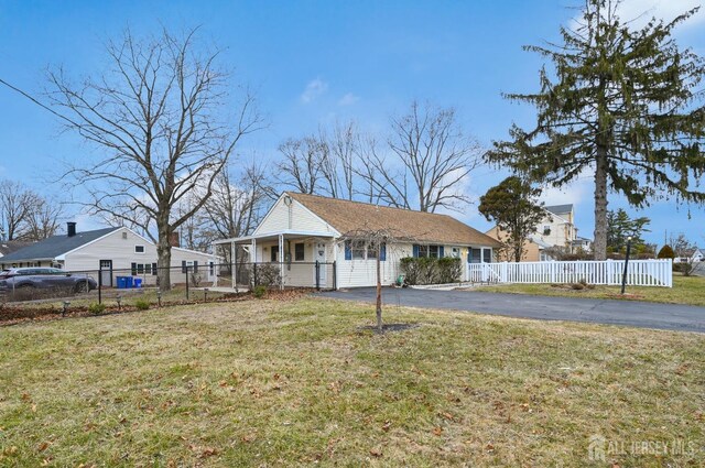 ranch-style home featuring covered porch and a front yard