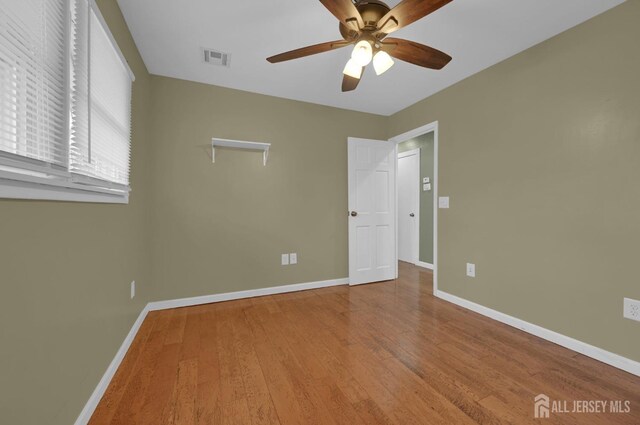 unfurnished bedroom with ceiling fan and hardwood / wood-style floors