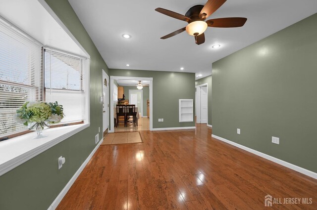 interior space with ceiling fan and wood-type flooring