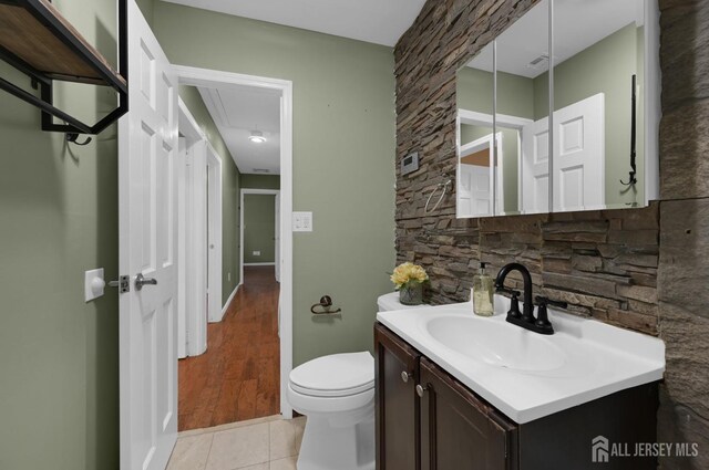 bathroom featuring toilet, tile patterned flooring, and vanity