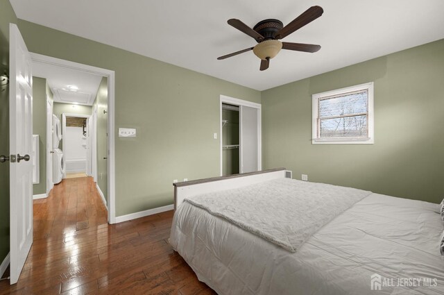 bedroom featuring ceiling fan, dark hardwood / wood-style flooring, and washer / dryer