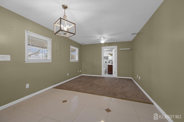 interior space featuring ceiling fan with notable chandelier and light tile patterned floors