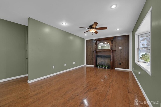 unfurnished living room featuring ceiling fan, hardwood / wood-style floors, and a fireplace