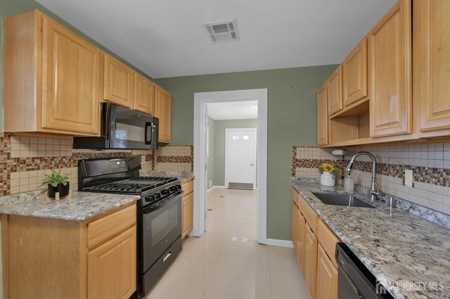 kitchen with black appliances, light tile patterned floors, sink, and light brown cabinets