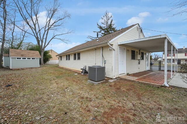 view of side of home with a lawn, cooling unit, and a storage unit