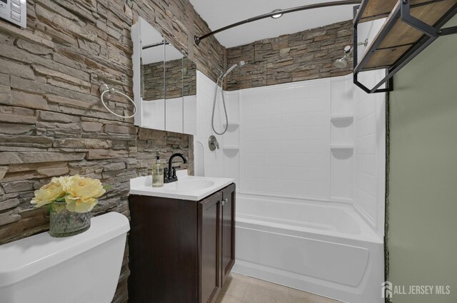 full bathroom with toilet, vanity, and washtub / shower combination